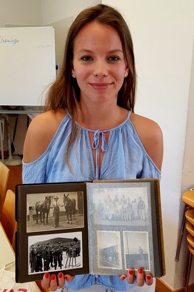 Schülerin mit Fotobuch des Ur-Ur-Großvaters aus dem ersten Weltkrieg